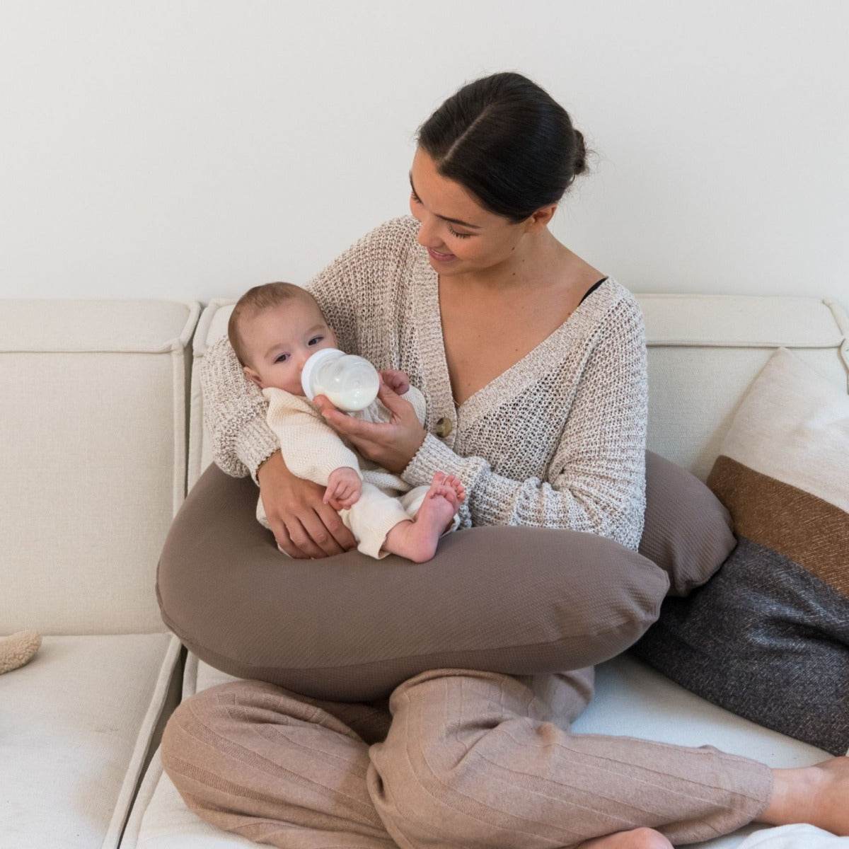 Women bottle feeding baby with Doo Moo Caribou Pregnancy Pillow