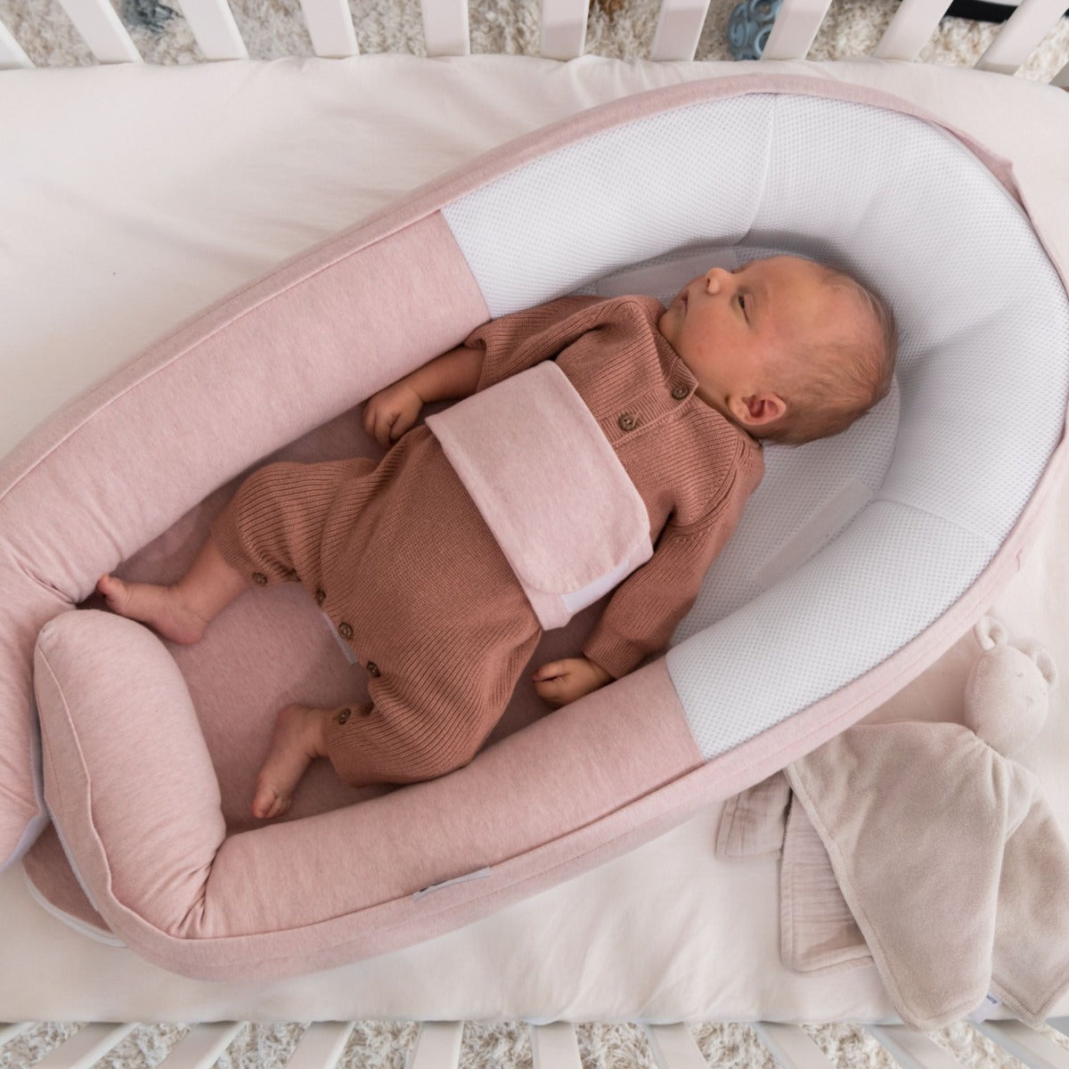 Baby peacefully resting in Doo Moo Cocoon nest in Chine pink
