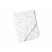 A folded white blanket with a subtle pattern of trees.