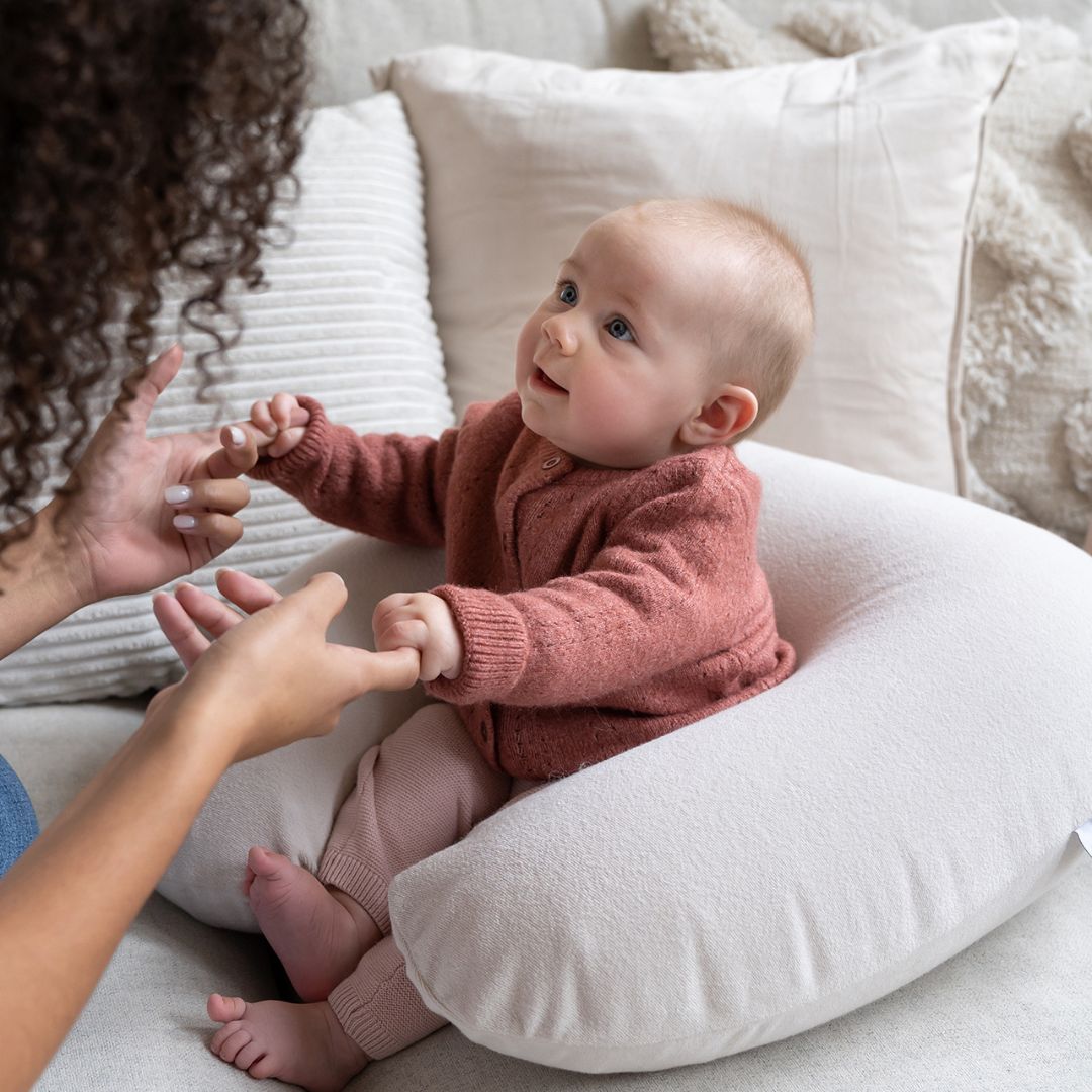 Baby sitting in Doo Moo Nursing Air Pregnancy Pillow Almond
