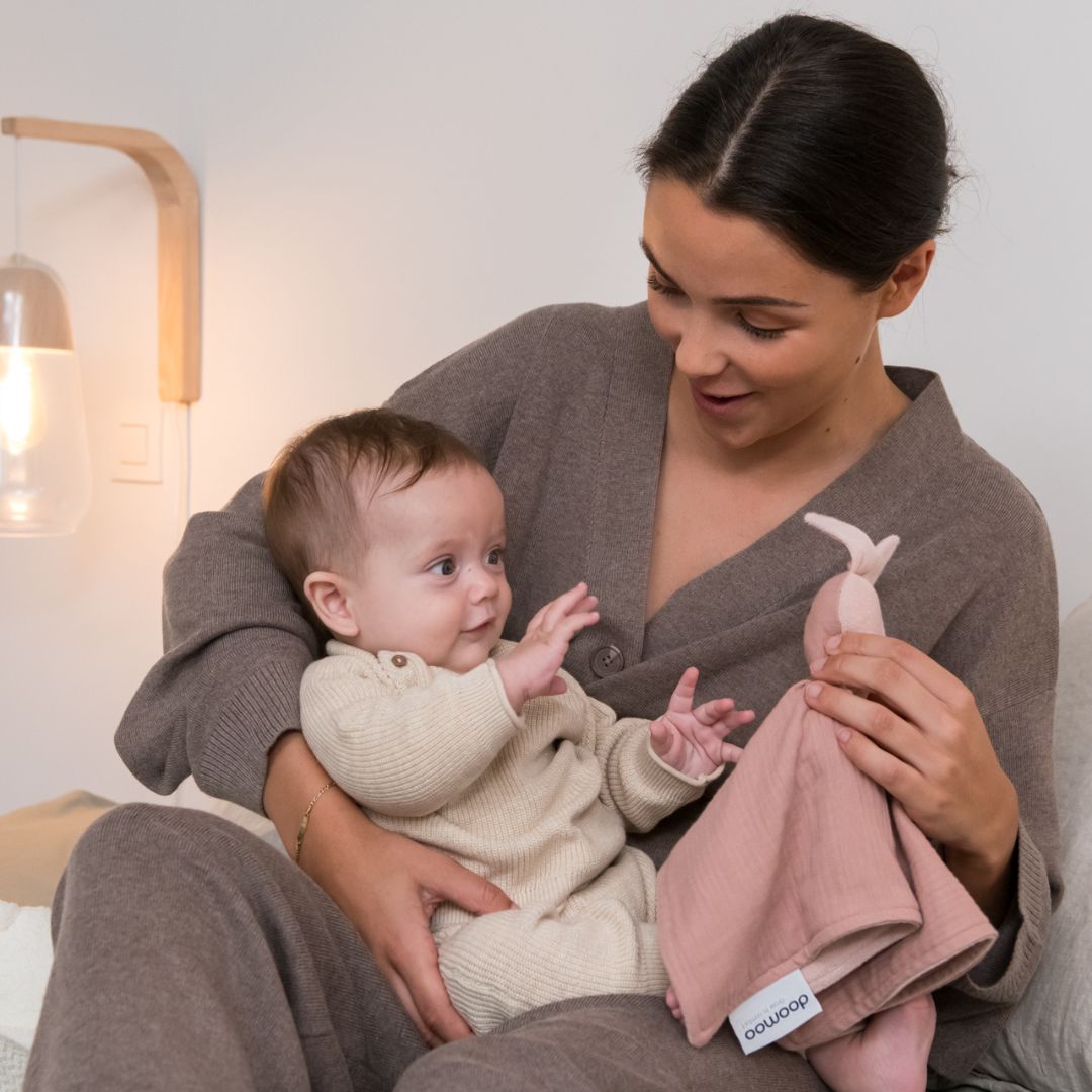 Mother and baby playing with doomoo bunny detachable baby soother in pink