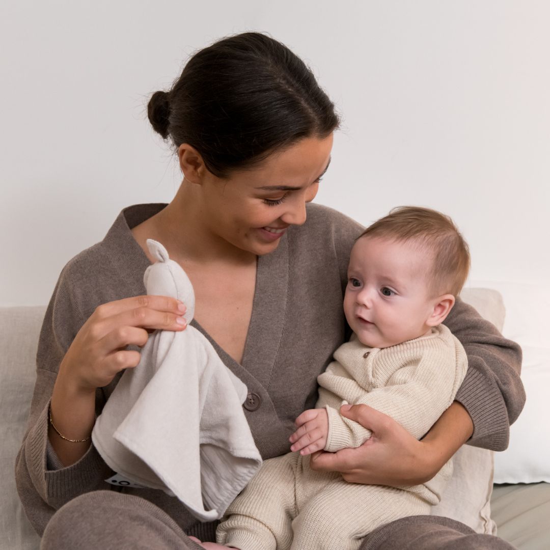 Mother and baby playing with doomoo bunny detachable baby soother in almond