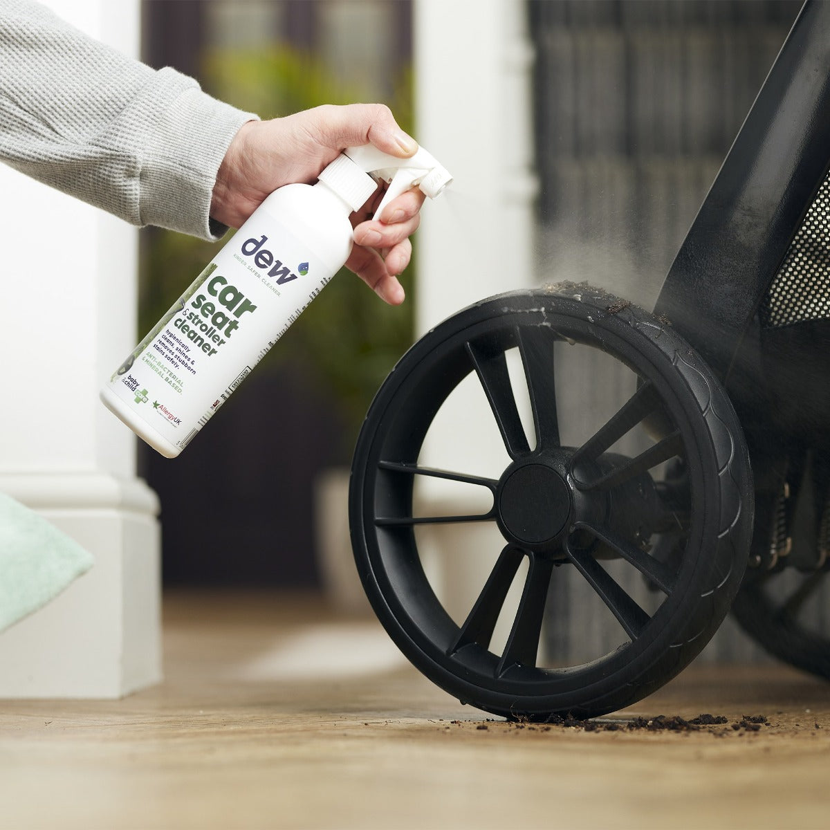 Mother cleaning stroller with car seat and stroller cleaning spray