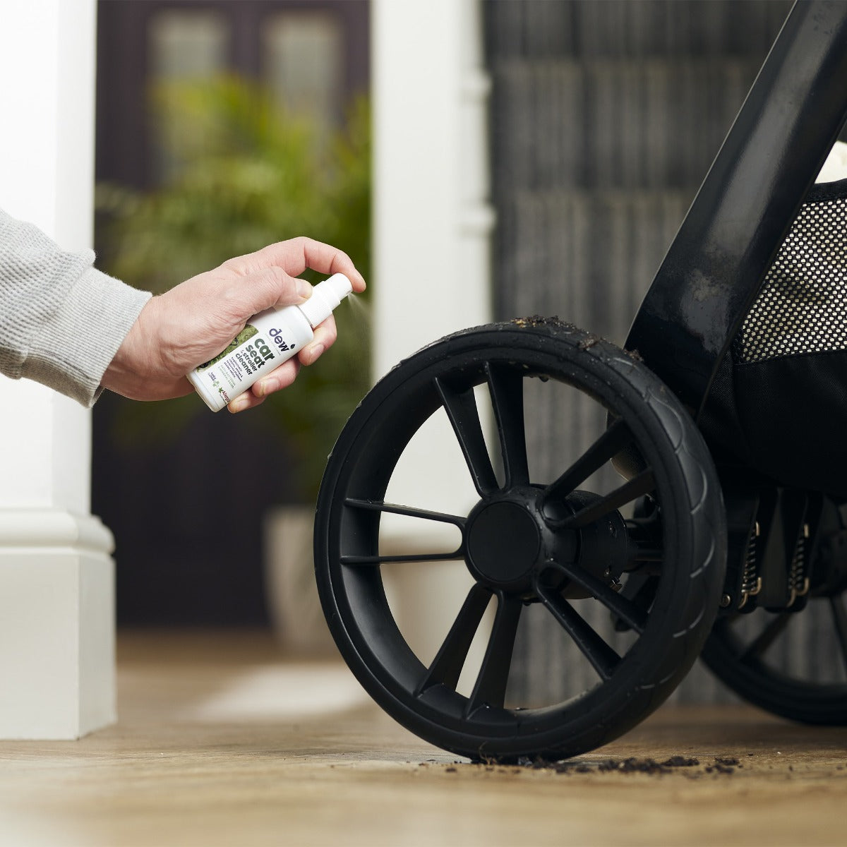 Mother cleaning stroller with car seat and stroller cleaning spray