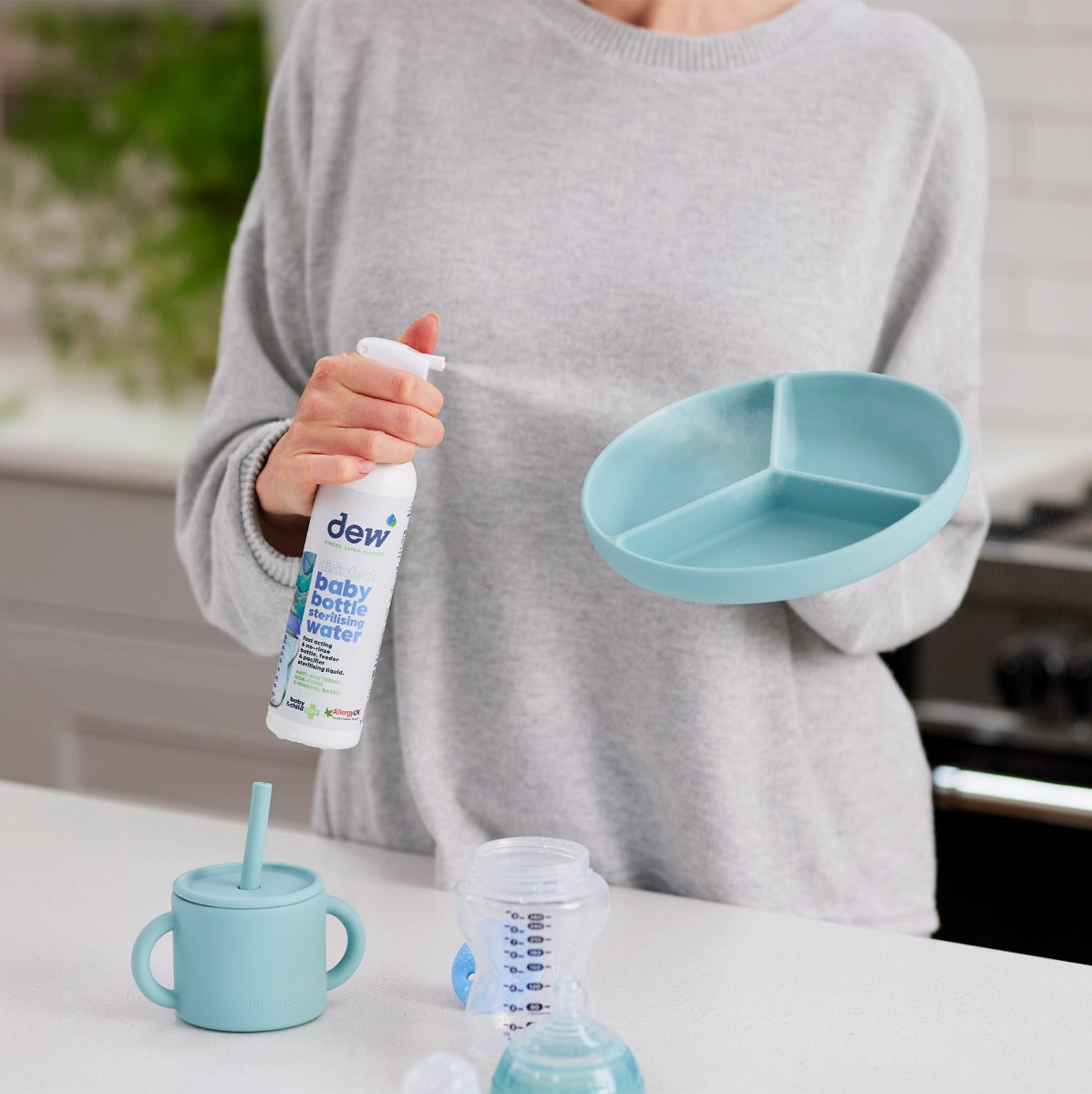 Mother spraying Dew Baby Bottle Sterilizing Water