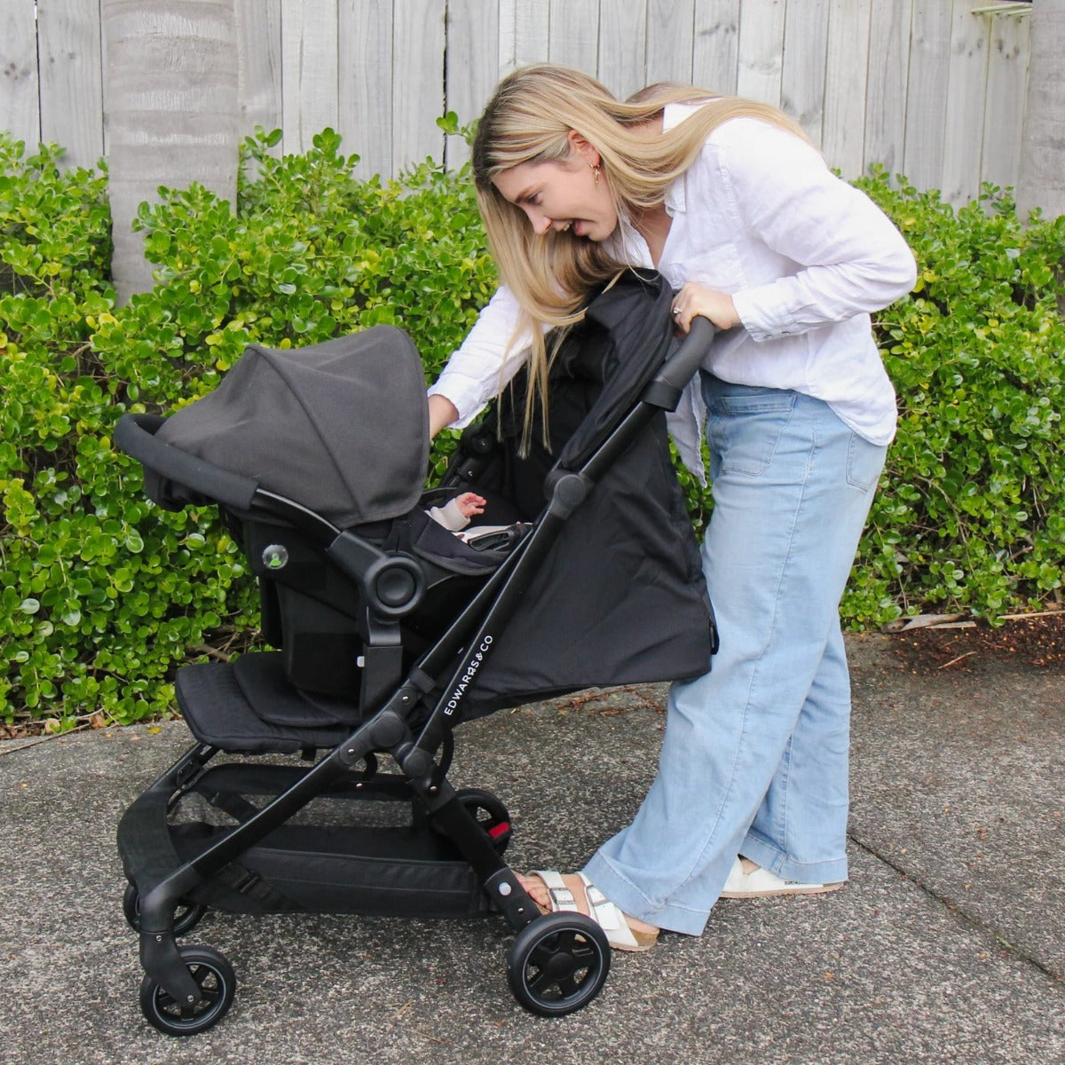 Mother with Edwards & co Lucci Stroller in black attached with Avery Capsule