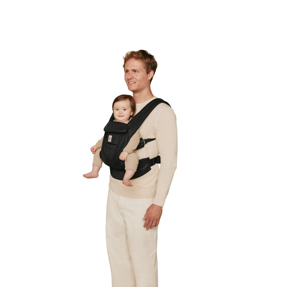 Father carrying baby forward facing in baby carrier