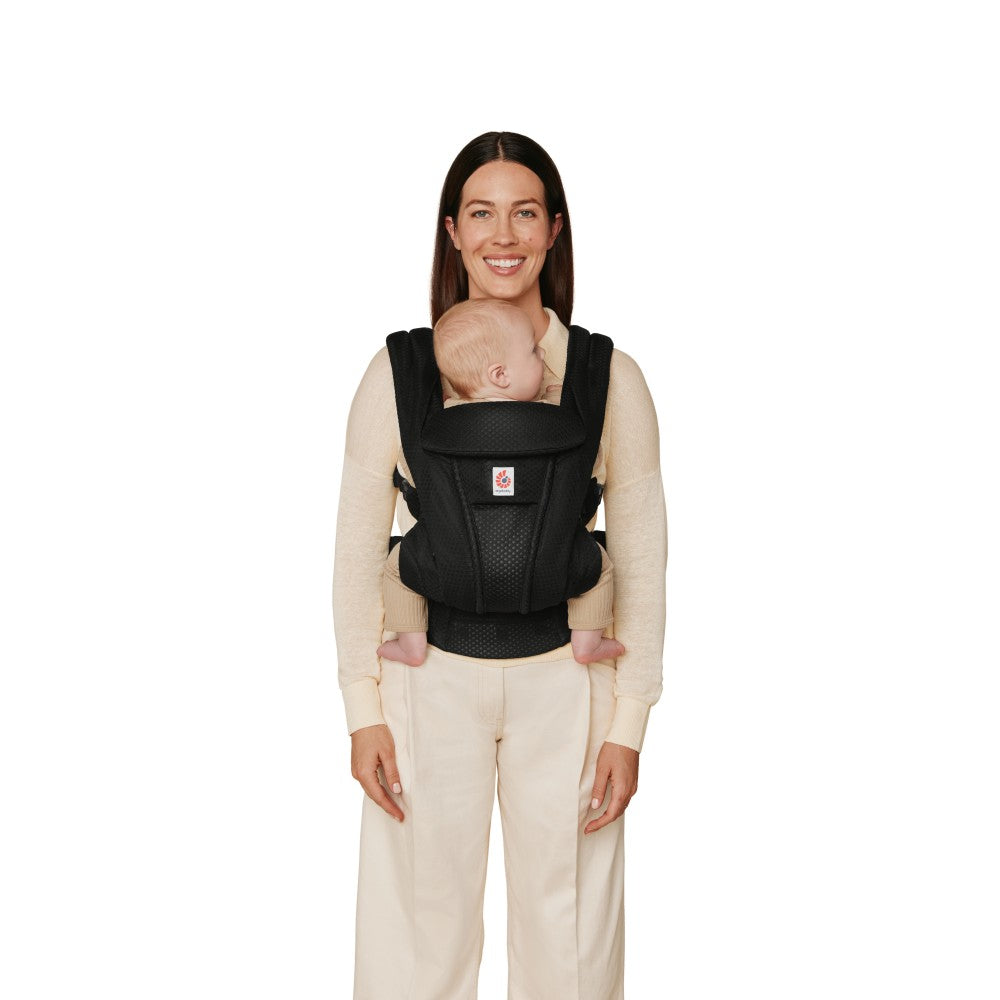 Mother carrying baby rear facing in baby carrier