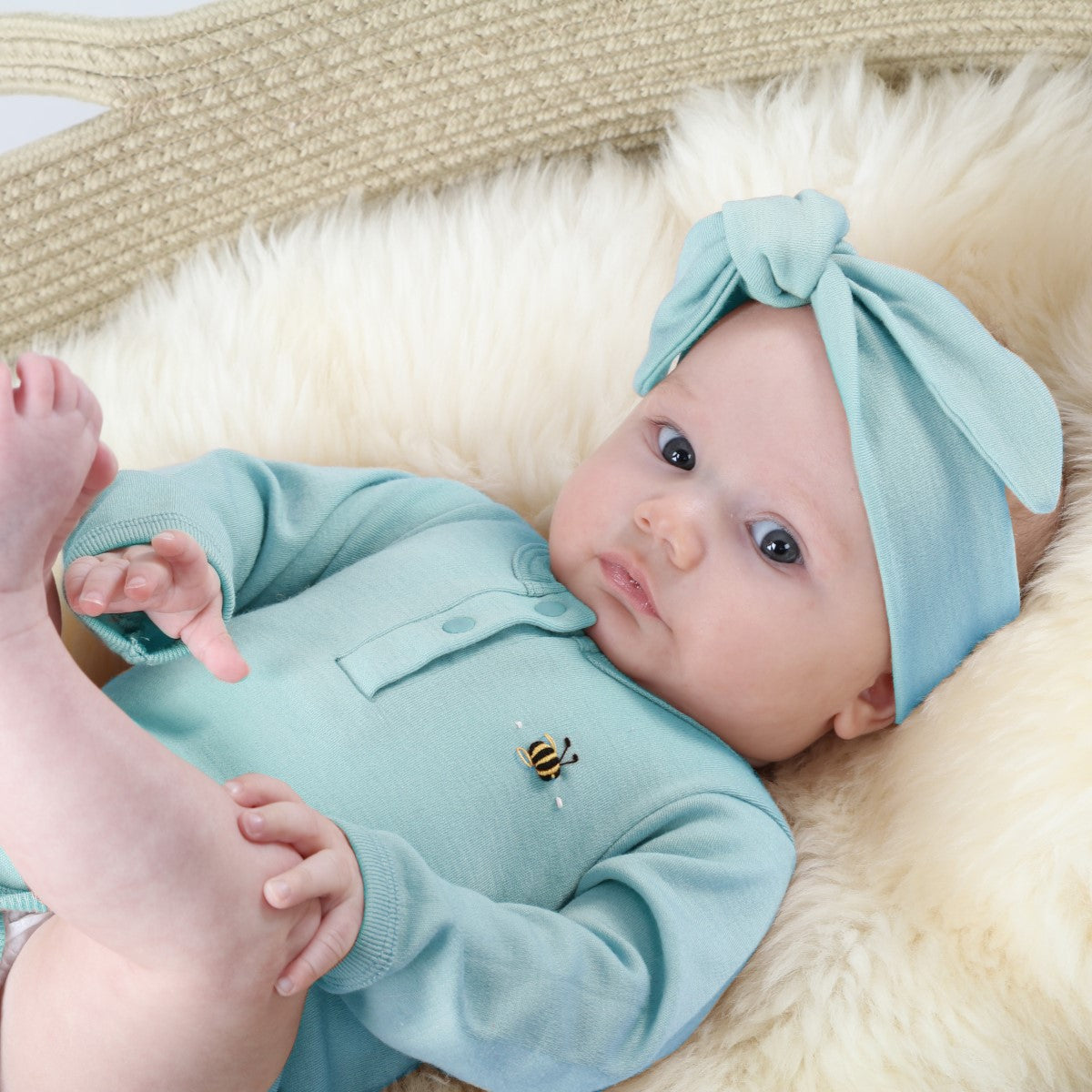Baby wearing Dimples by Jane Anne Merino Bodysuit Fall Fiesta Teal Bee with a teal headband