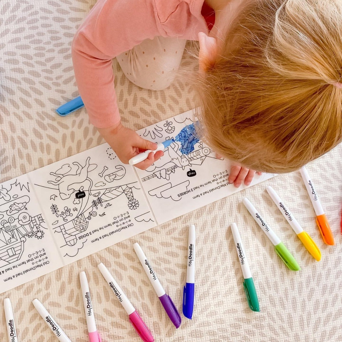 Baby girl colouring on HeyDoodle Farm story silicone reusable colouring mat