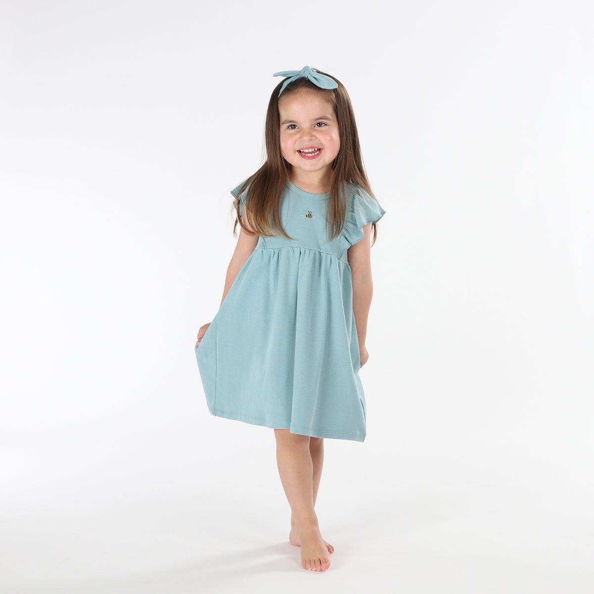 Baby girl wearing Cotton frill dress in ocean and bee embroidery pairing it with tie headband