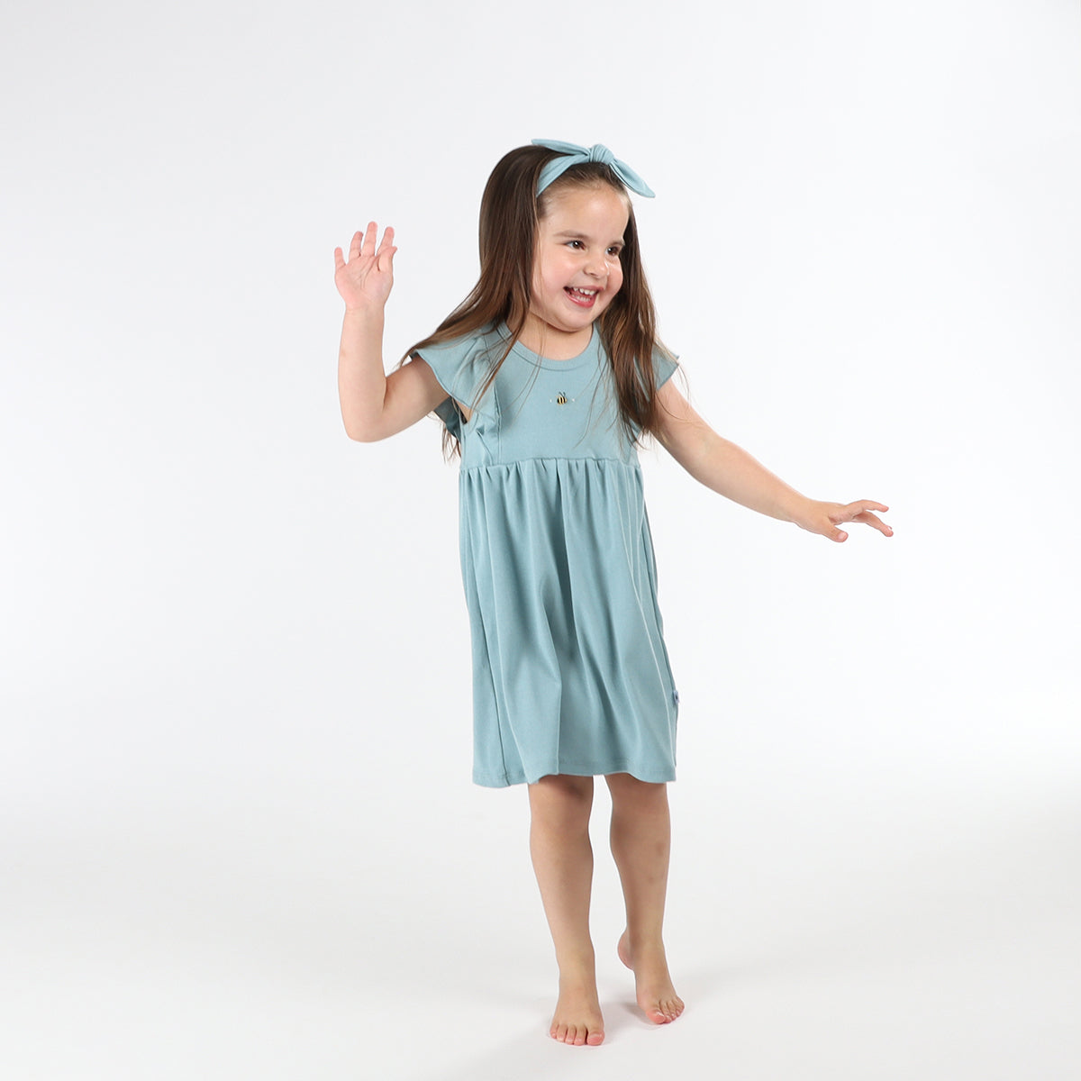 Baby girl wearing Cotton frill dress in ocean and bee embroidery pairing it with tie headband