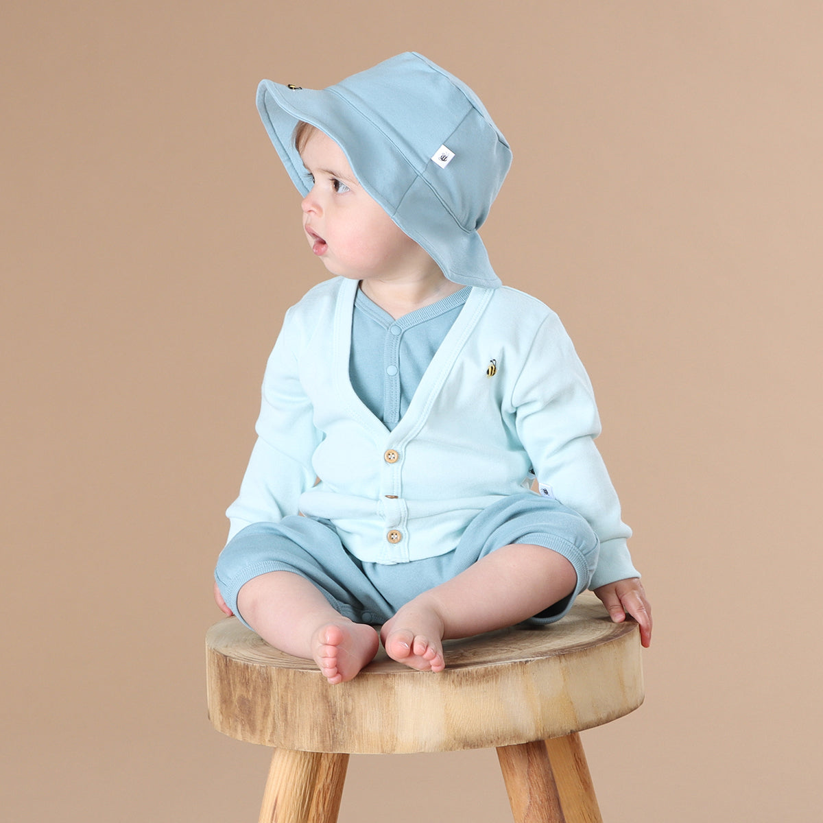 Little girl wearing Dimples summer 2022/23 collection pastel skies cotton cardigan in Blue