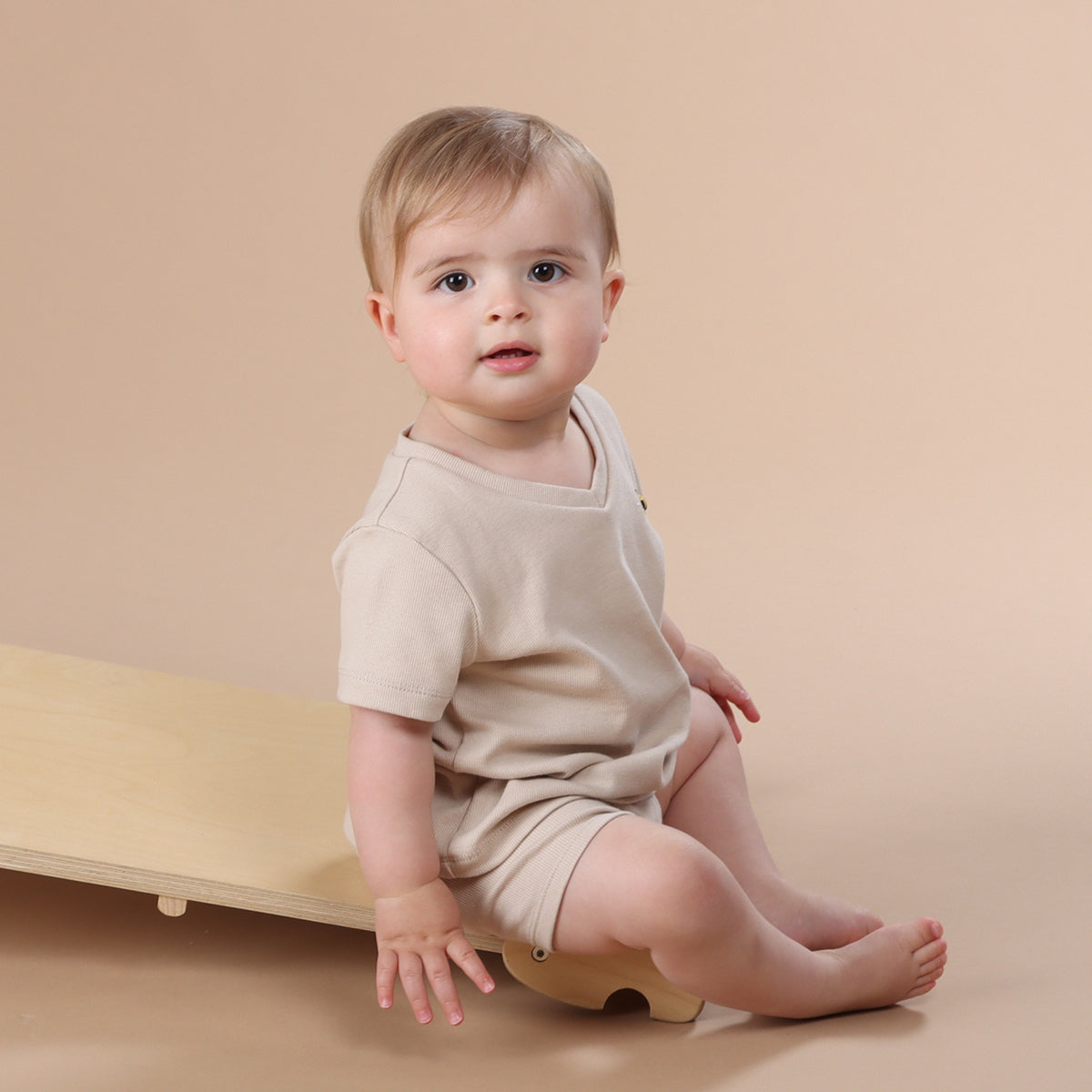 Baby wearing Dimples Cotton T-shirt in sand colour