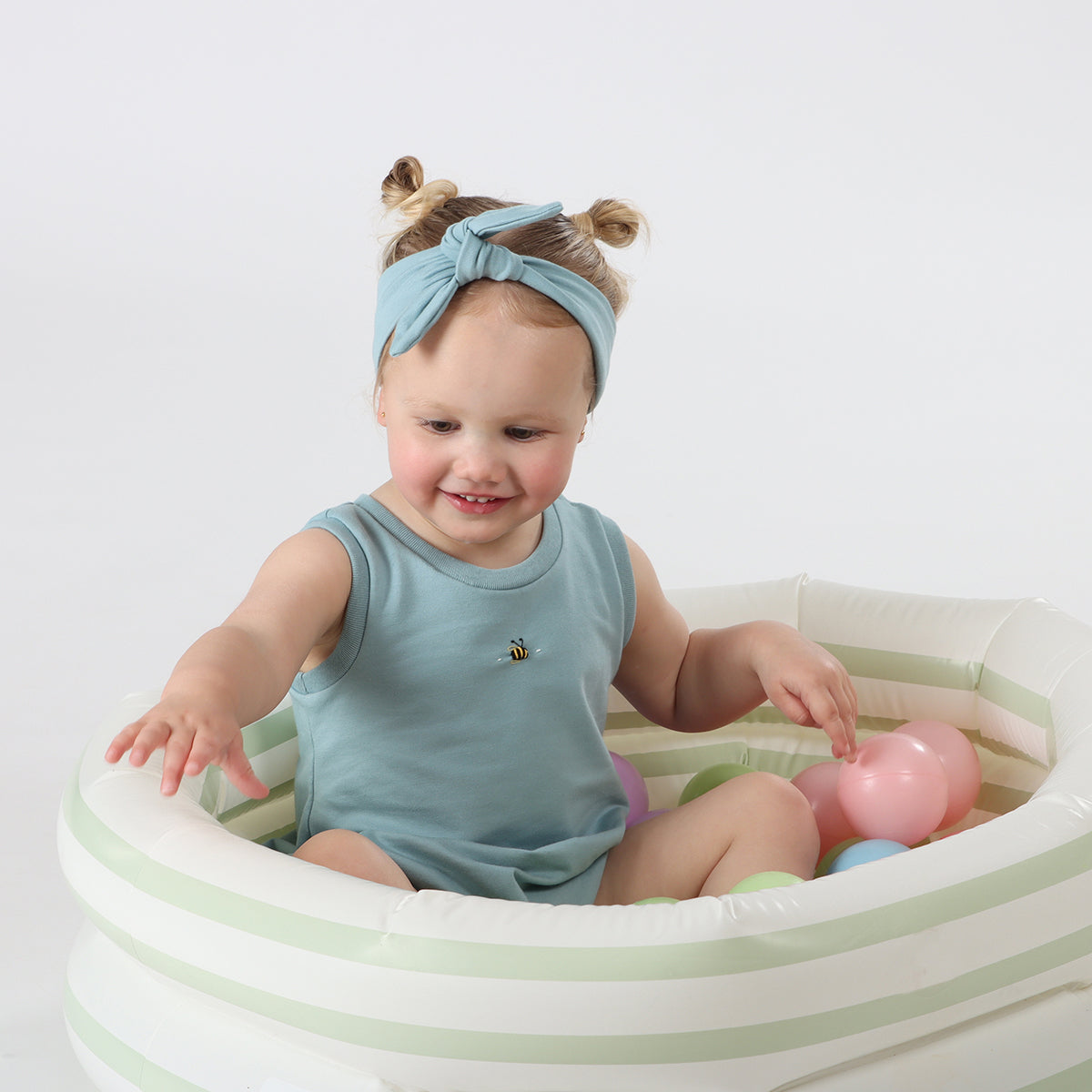 Baby girl playing wearing bodysuit Cotton Tie Headband in ocean