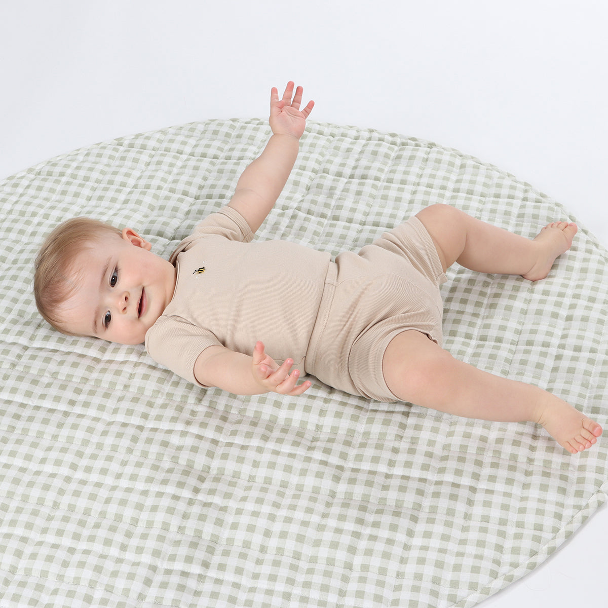 Baby laying down wearing dimples biker shorts in sand bee colour from the summer 2024 hidden treasures collection