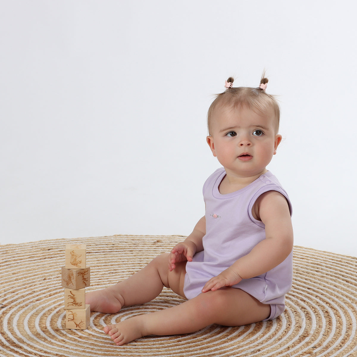 Baby sitting wearing Cotton Slouch Bodysuit in lilac with rose embroidery