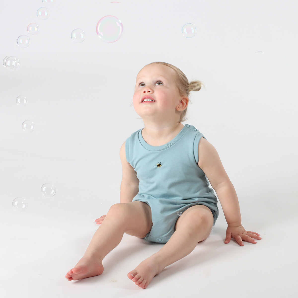 Baby playing wearing cotton slouch baby bodysuit with bee embroidery