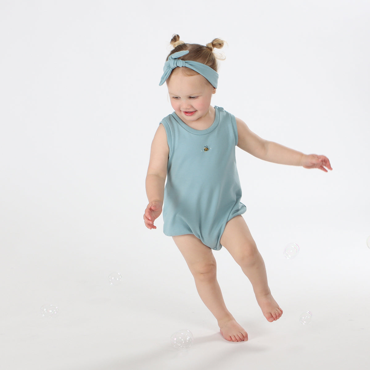 Baby playing wearing cotton slouch baby bodysuit with bee embroidery