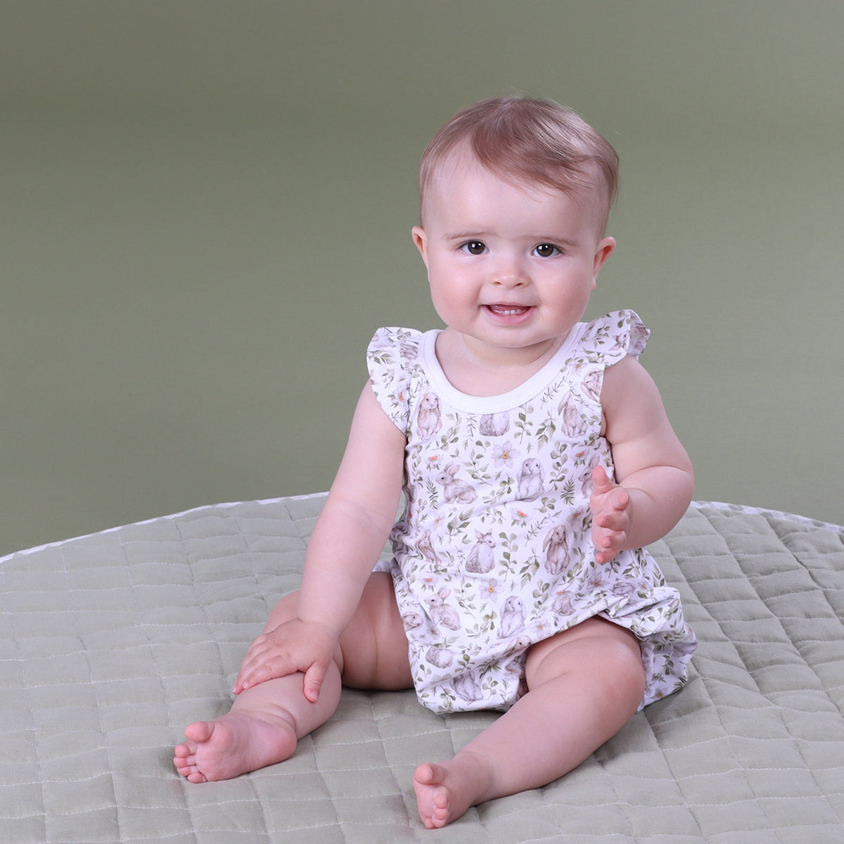 Little girl looking at the camera wearing Little Bee Bunny Cotton Romper from the Isabelle & Harper Collection