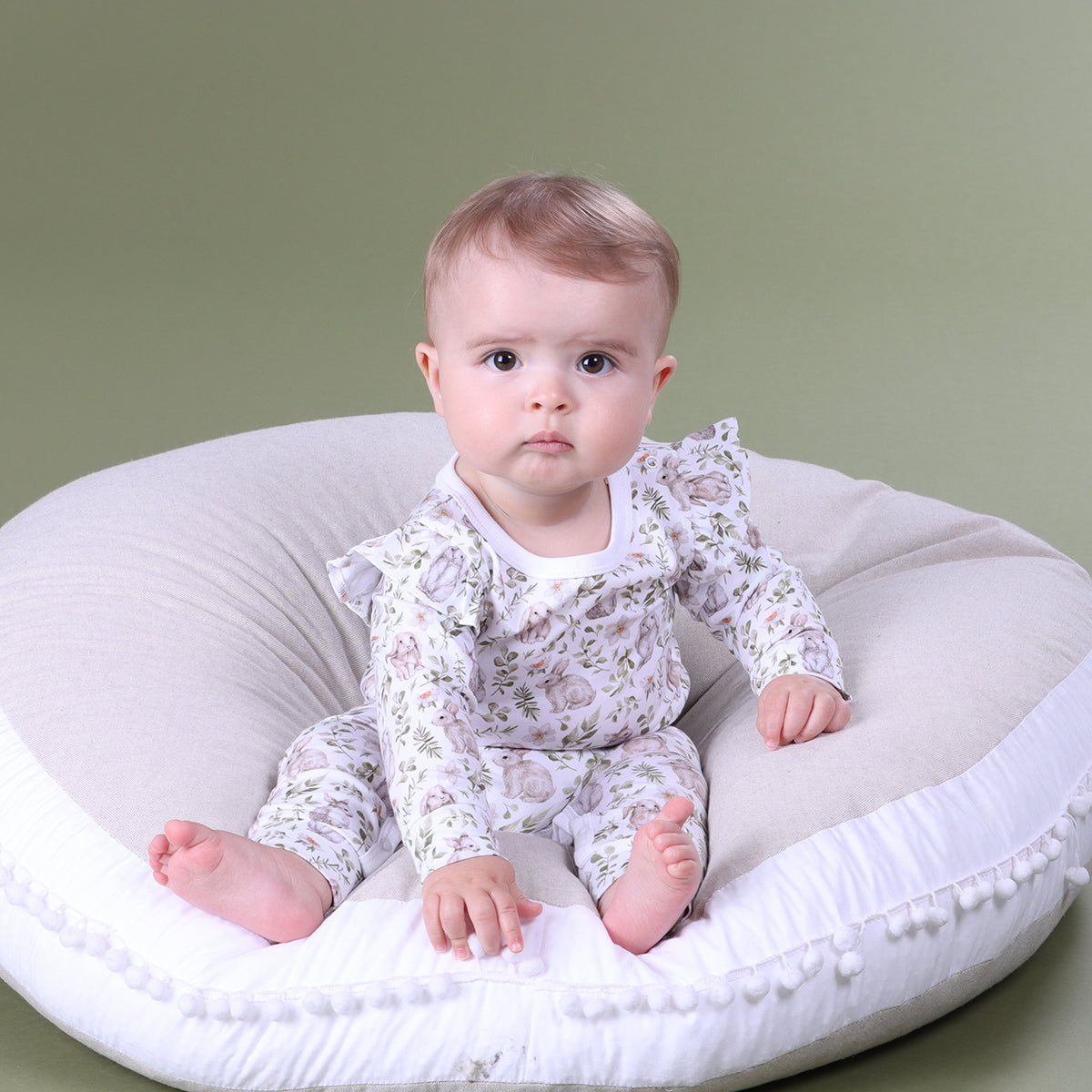 Baby girl sitting wearing Little bee by Dimples Cotton Frill Babygorw with bunny print