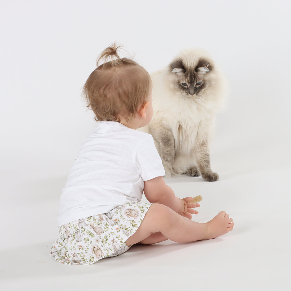 Little baby crawling toward a cat while wearing  Little Bee By Dimples Bunny Cotton Skirt