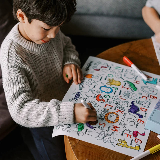 Baby boy colouring on HeyDoodle silicone reusable colouring mat with letters and animals