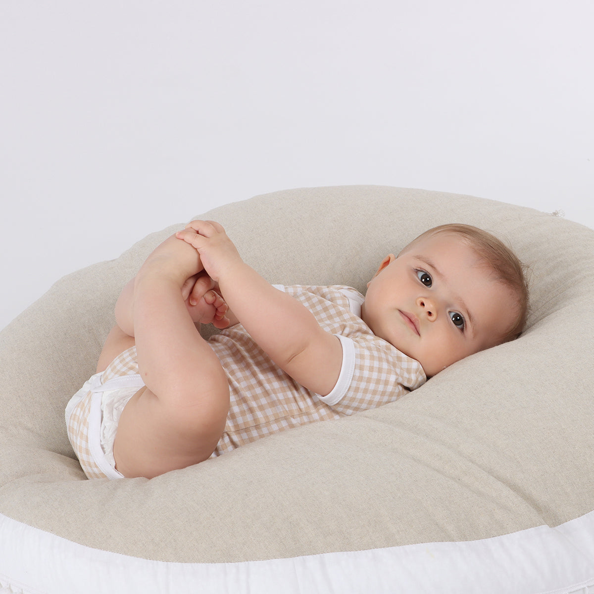 Baby in lounger wearing Organic cotton gingham bodysuit