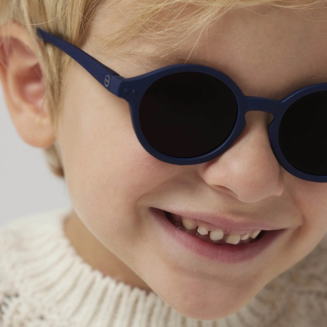 Baby boy wearing Izipizi sunglass in denim blue