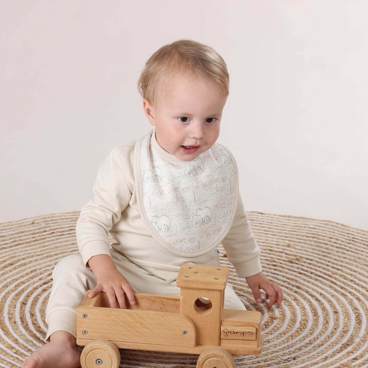 Baby wearing Animal print cotton bib playing with toys