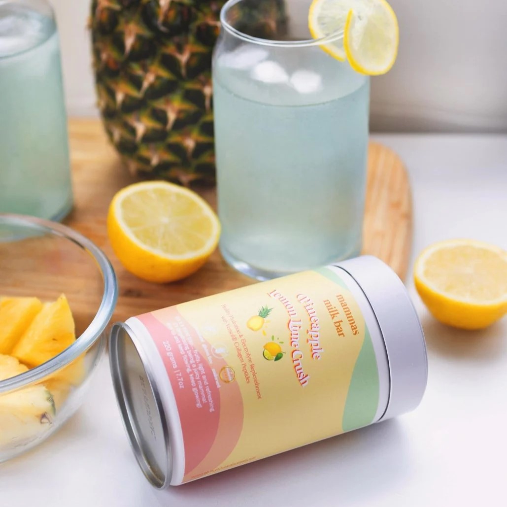 sample glass of Pineapple Lemon & Lime Hydration & Electrolytes with lemons on side