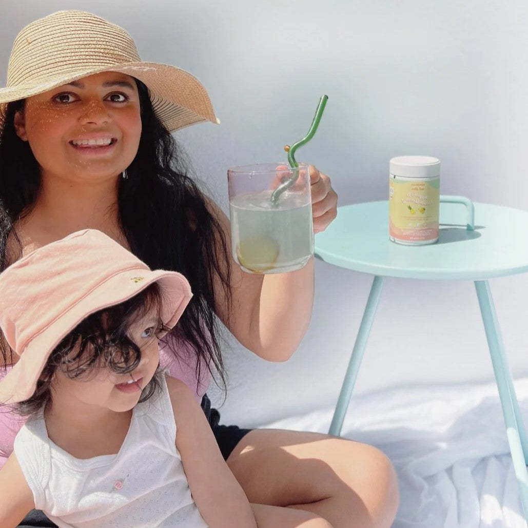 Mother enjoying Pineapple Lemon & Lime Hydration & Electrolytes with baby sitting with her.