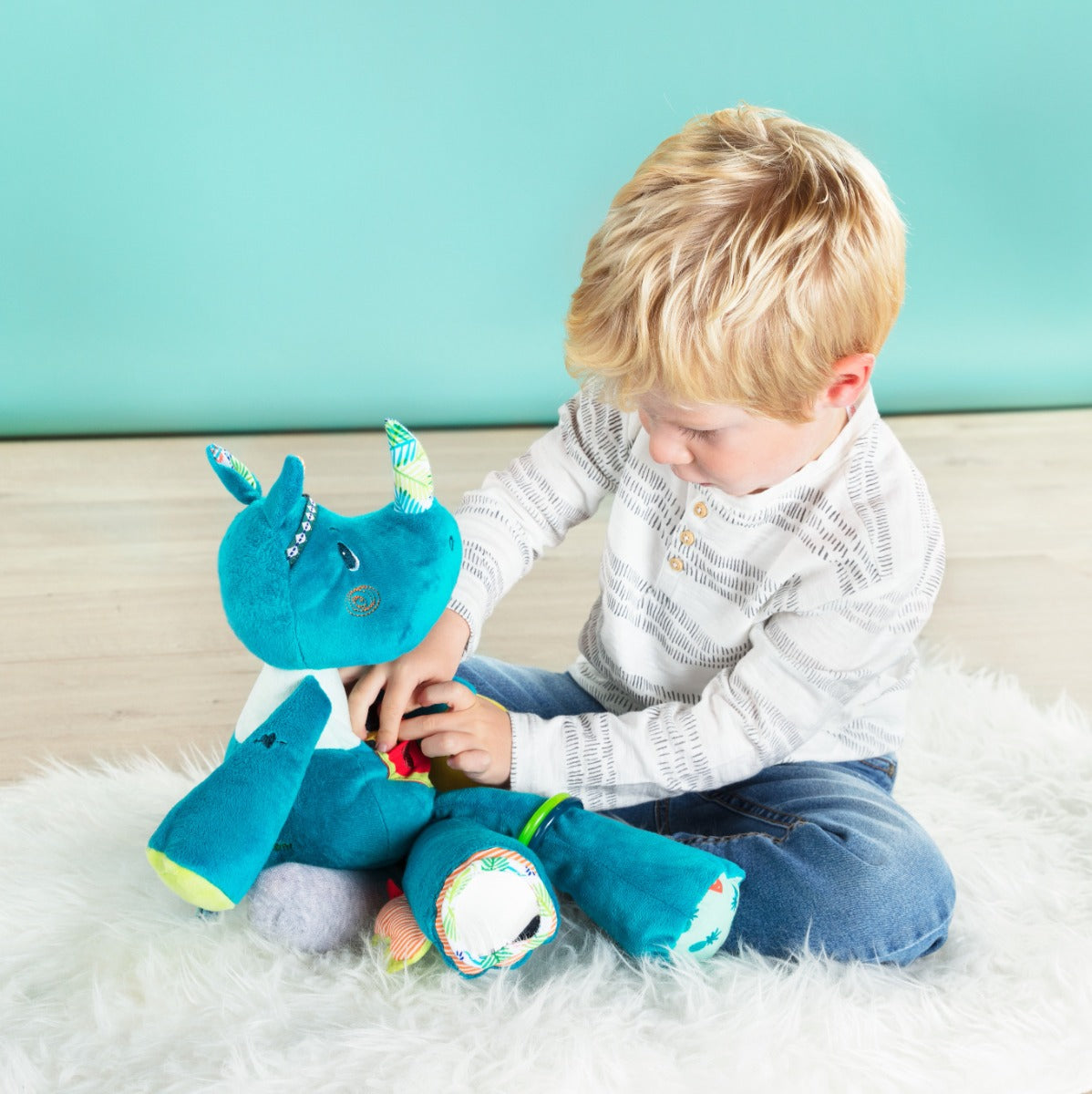 Toddler boy playing with Lilliputiens Marius Rhino Activity Cuddle 