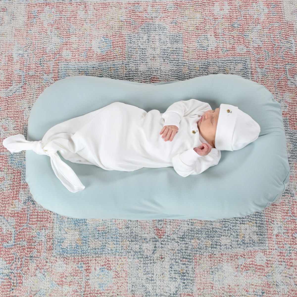 Baby sleeping wearing tie gown and beanie