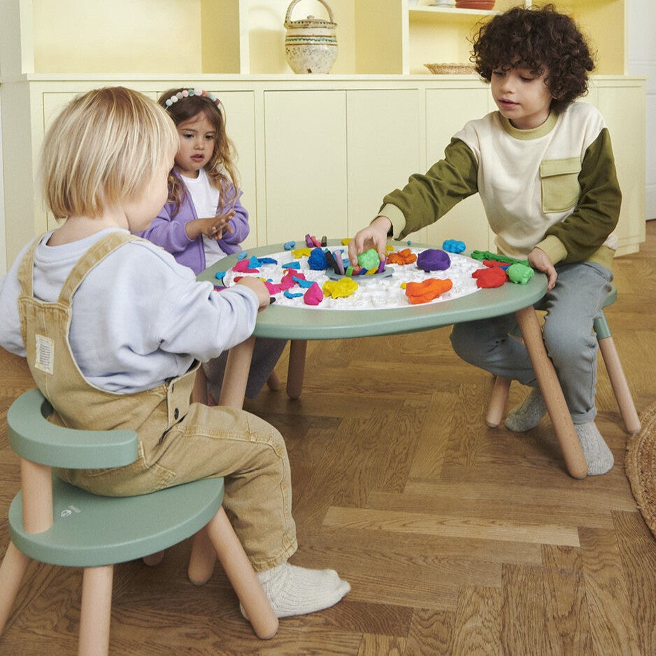 Kids playing on Mutable Play Dough Board from Stokke with playdough