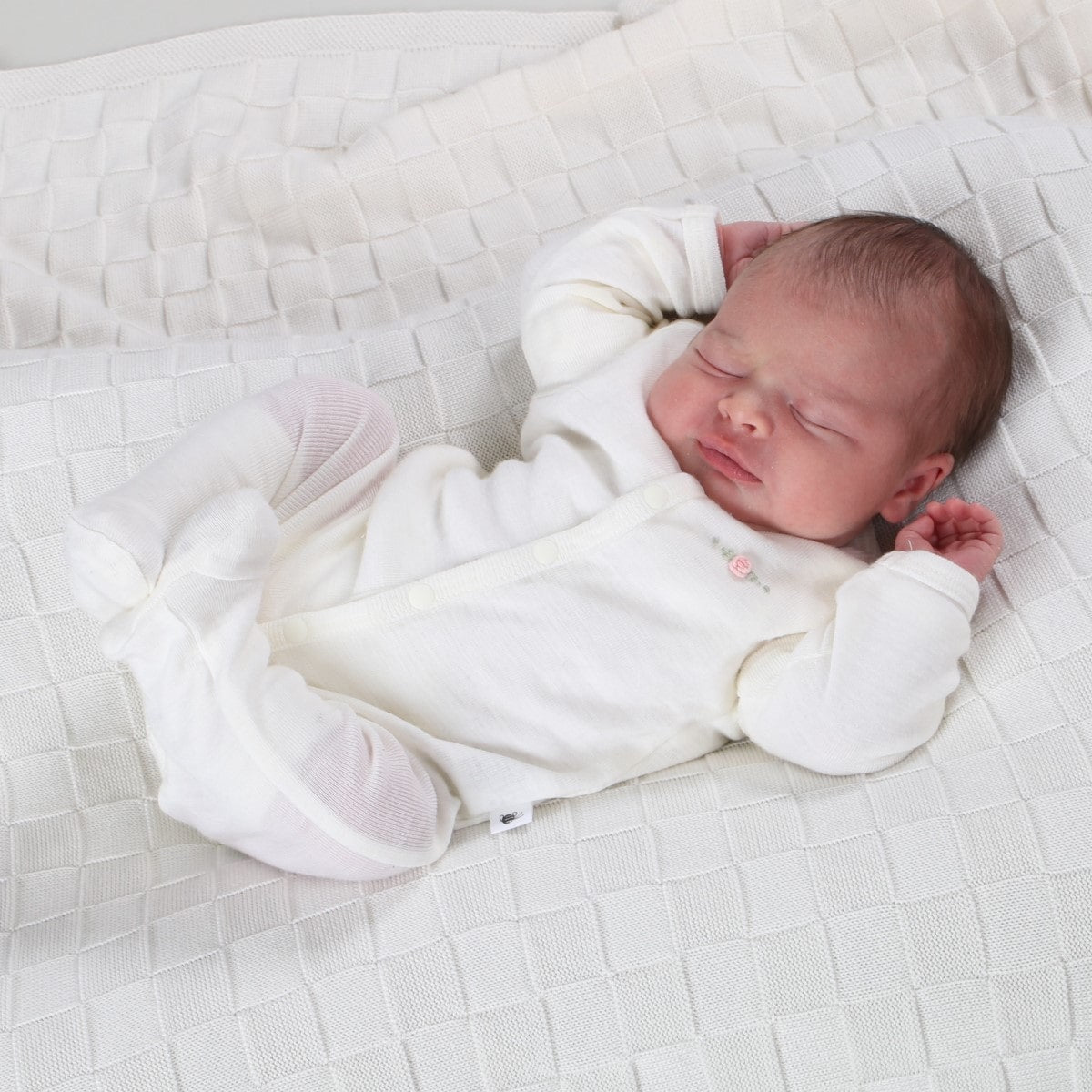 Dimples Classic Merino Newborn baby clothes - babygrow onesie in cream rose on baby