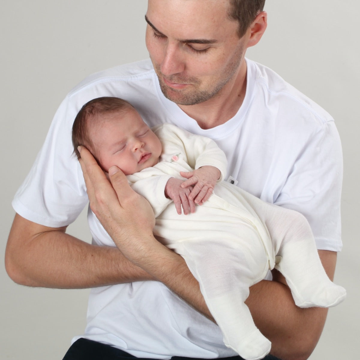 Dimples Classic Merino Newborn baby clothes - babygrow onesie in cream rose on baby held by dad