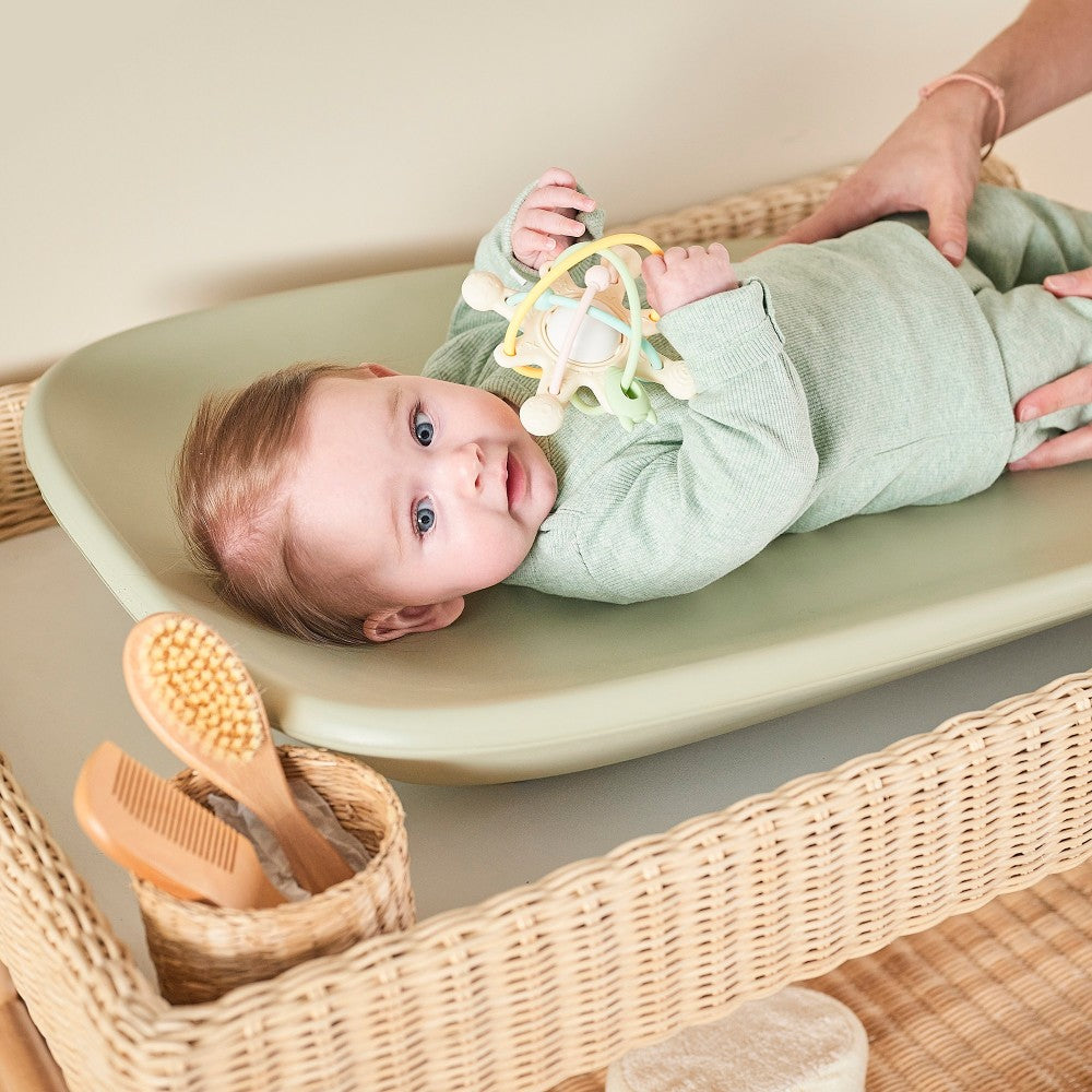 Baby enjoying nappy change time on Baby Change Mat from Nattou in green
