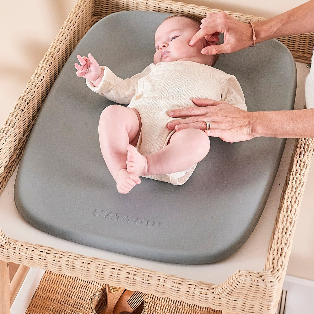 Mother playing with baby who is lying on Baby Change Mat from Nattou in grey