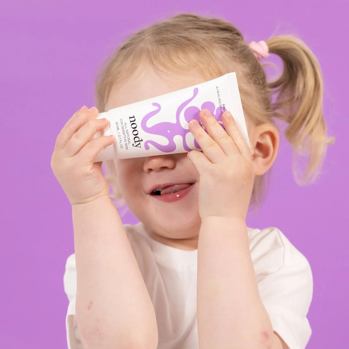 Baby girl holding Noody Calm Balm