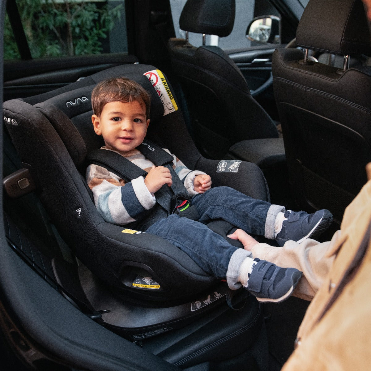 Baby boy sitting in a Pruu car seat in car back seat