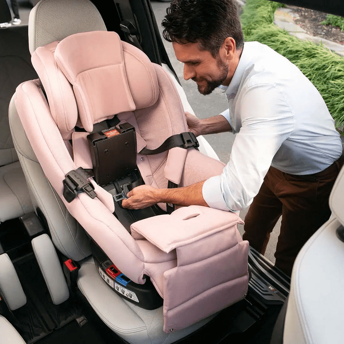 Father installing Nuna Rava car seat in Thistle color in car