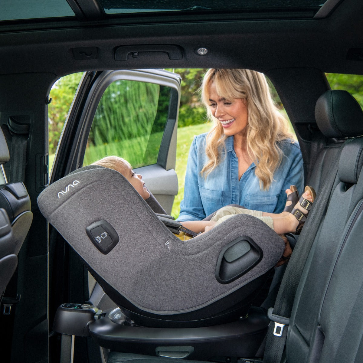 Mother putting baby in a car seat with rear facing setting in Nuna Todl Next