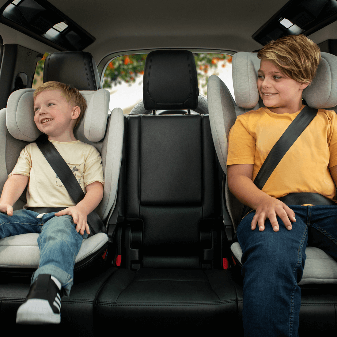 Kids sitting happily in aace lx car seat in car