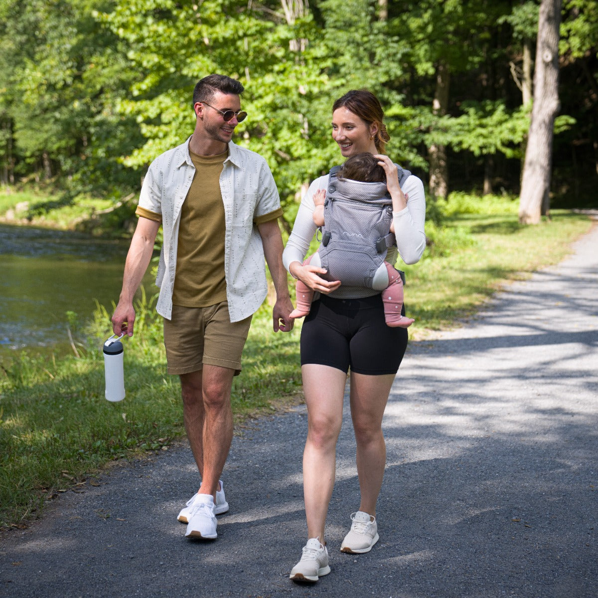 Parents out in the park with mother carring baby in Nuna Cudl Clik Baby Carrier