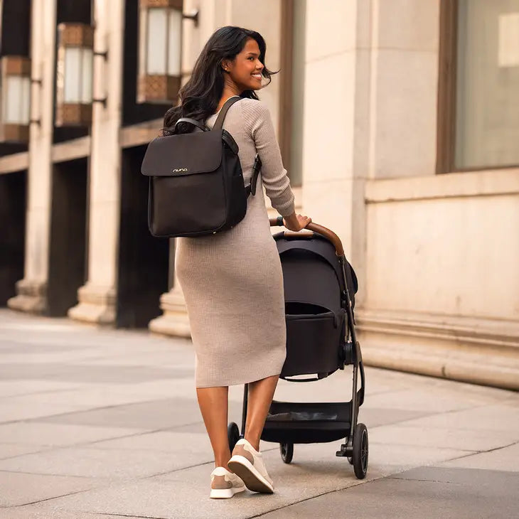 Mother walking with Nuna stroller and Diaper bag om back