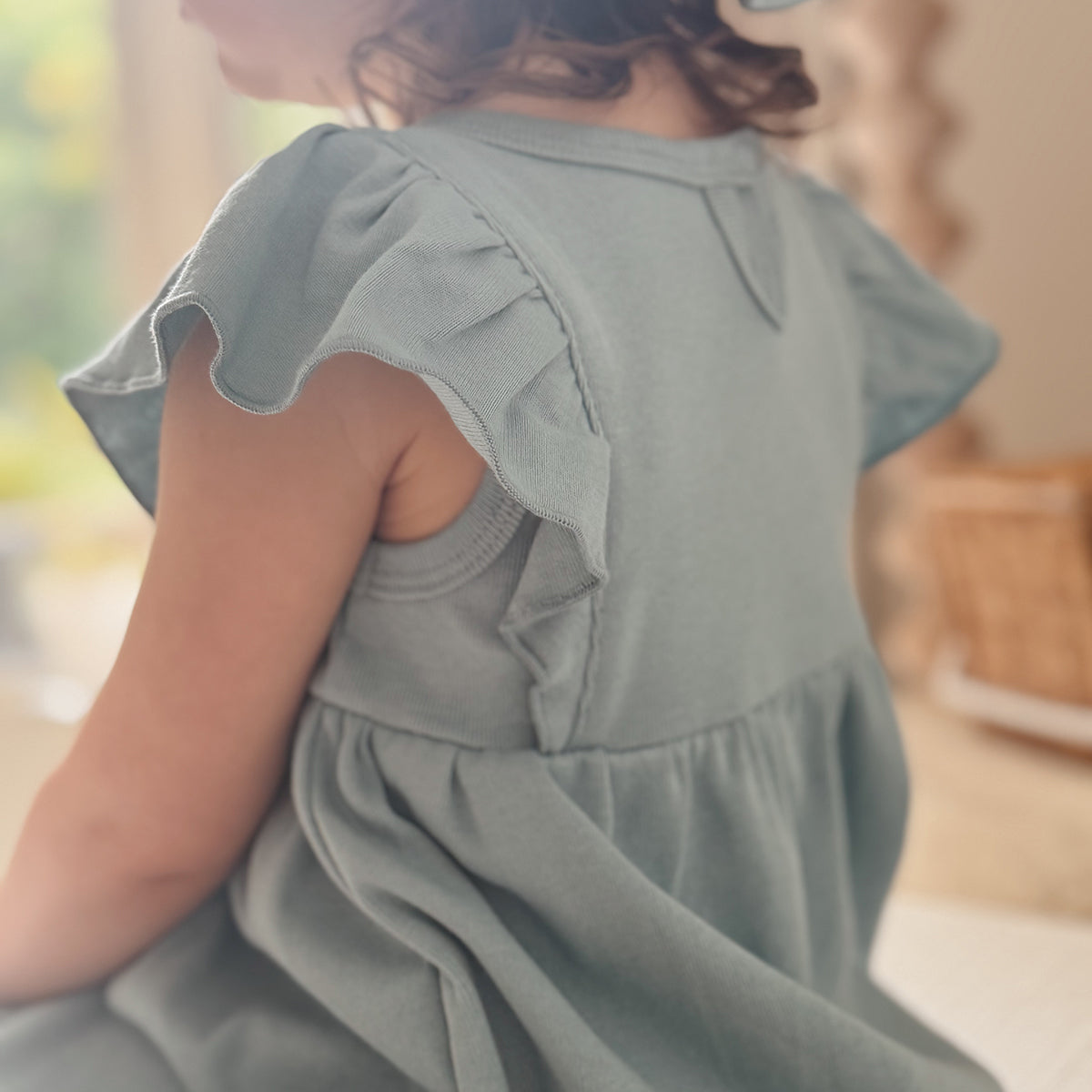 Baby girl wearing Cotton frill dress in ocean and bee embroidery back view