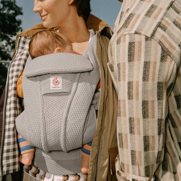 Front view Mother carrying baby in mesh breathable baby carrier