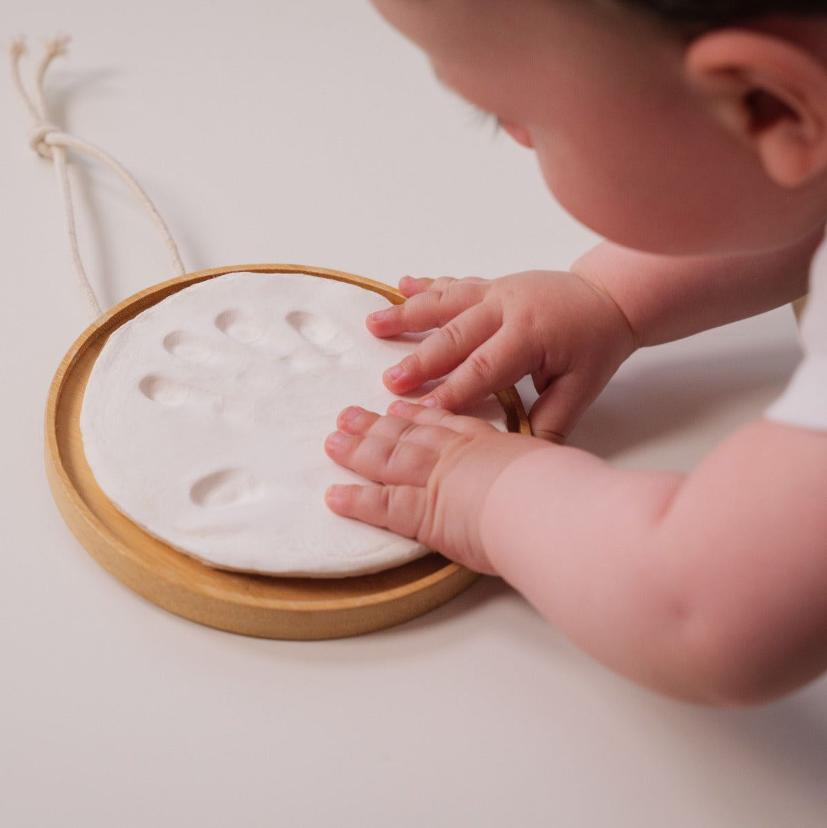 Baby imprinting hand on hypoallergic clay in wooden hanging:image,small_image,thumbnail,swatch_image