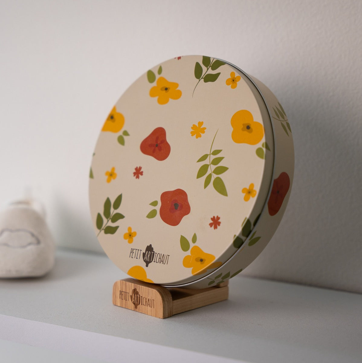 Petit Artichaut baby box round in little prairie print closed and place on a dresser
